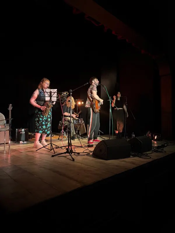 A full band with saxophone, drums and guitar on stage at Bromley Little Theatre