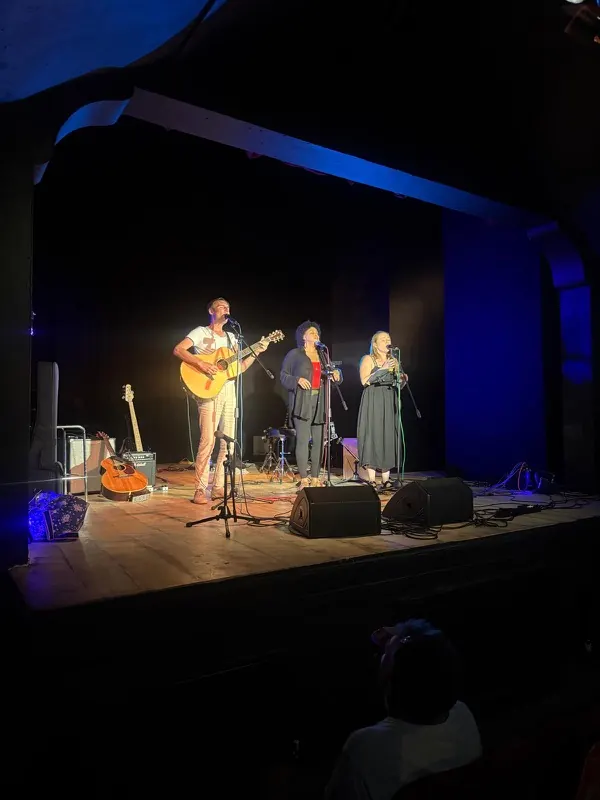 A guitarist and two singers performing three-part harmony at Bromley Little Theatre