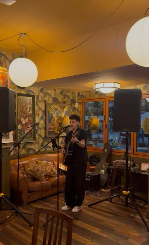 A solo performer singing and playing guitar at Pedro Lounge